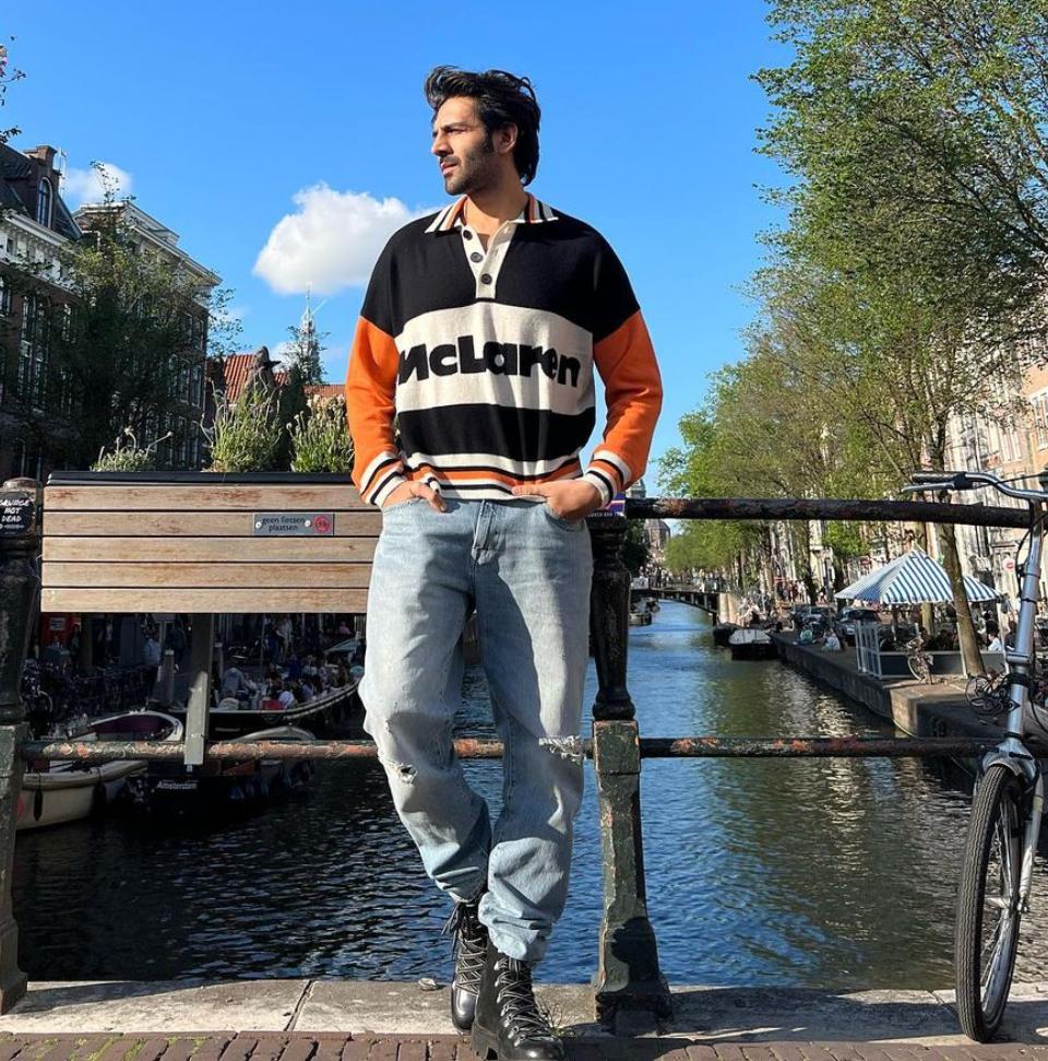 Swagster in sweatshirt 
The 'Pati, Patni Aur Woh' star, who went on a Europe trip with his team back in July this year, had treated his fans with a series of postcard worthy pictures on the Gram. In one of his photos, Kartik was seen wearing a cool sweatshirt along with loosely-fitted light blue ripped denim jeans. His sweatshirt which boasted hues of black, white and orange, had a collar with stripes. His sweatshirt, which was slightly oversized, gave him a vintage look. The black ankle length boots simply amped up his swag to another level. In case you are planning a winter vacation, then look no further because this look of Kartik's can help you up your fashion game.